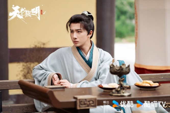 still of Li Hong Yi sitting at a table playing Hua Fu Sheng in Treasure at Dawn